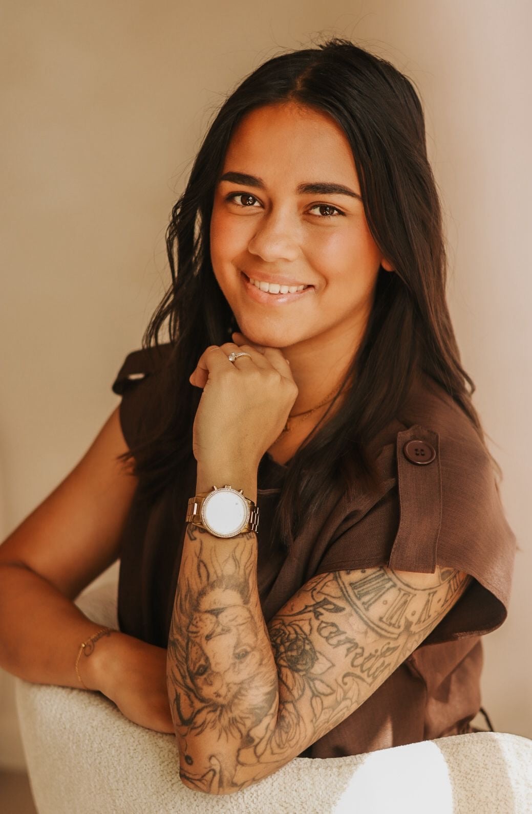 Christy Dollyana, lachend, leunend op een stoel