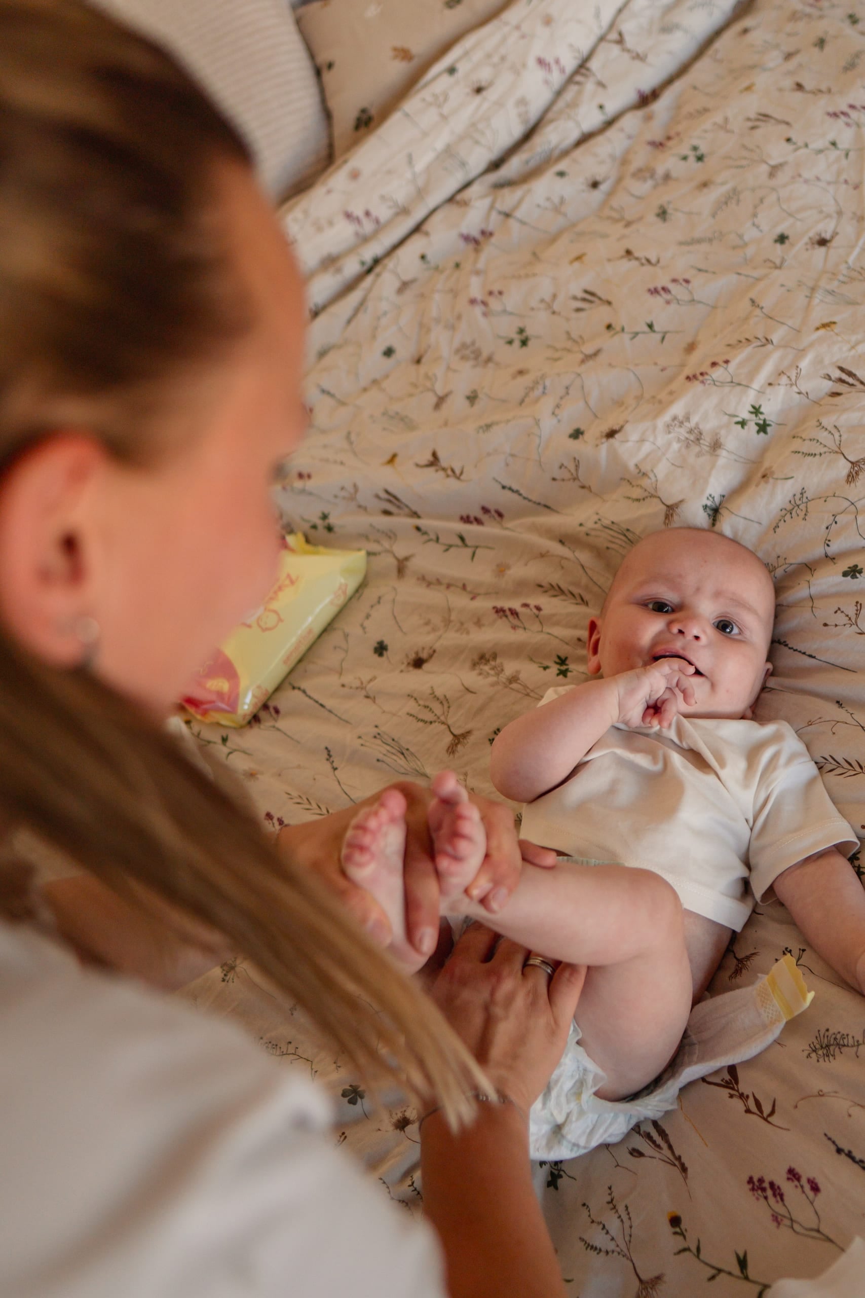 Moeder buigt zich over haar pasgeboren baby die op een deken ligt
