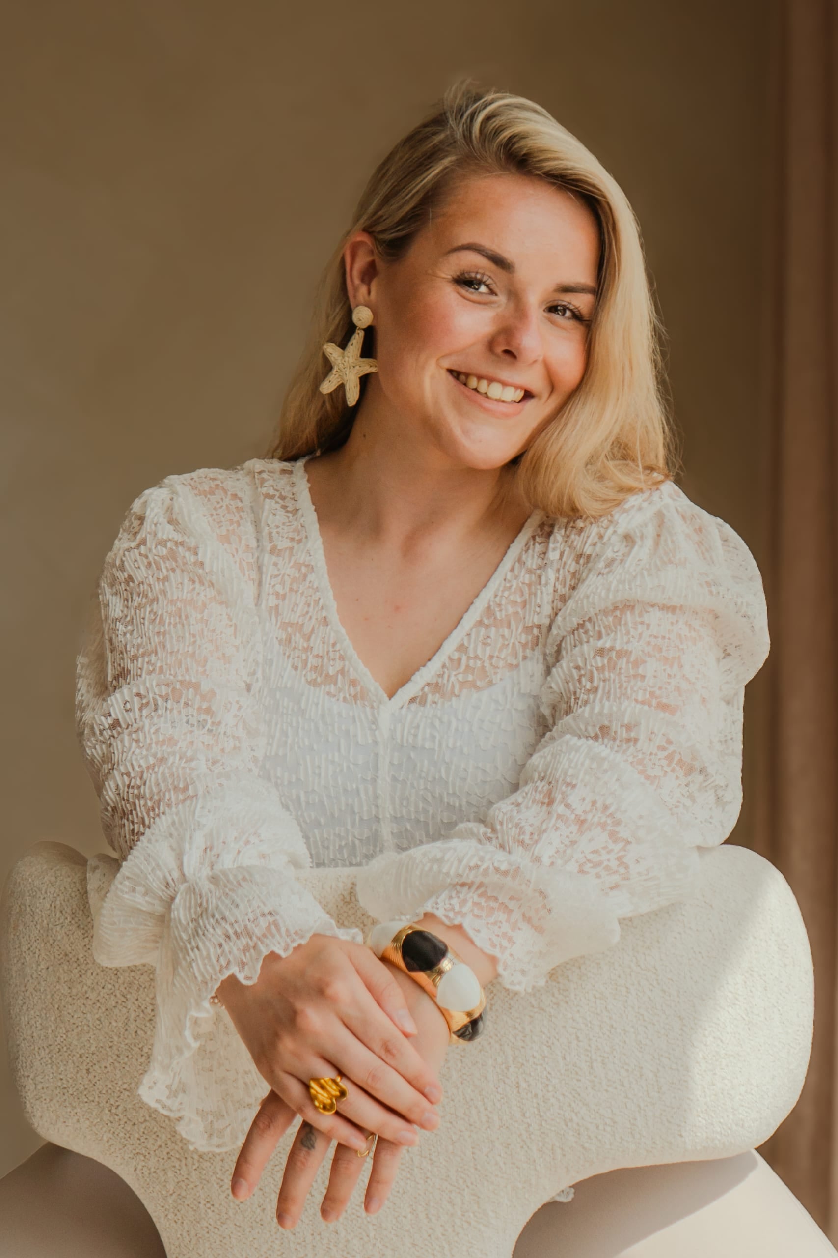 Portret van een lachende vrouw in een witte kanten blouse