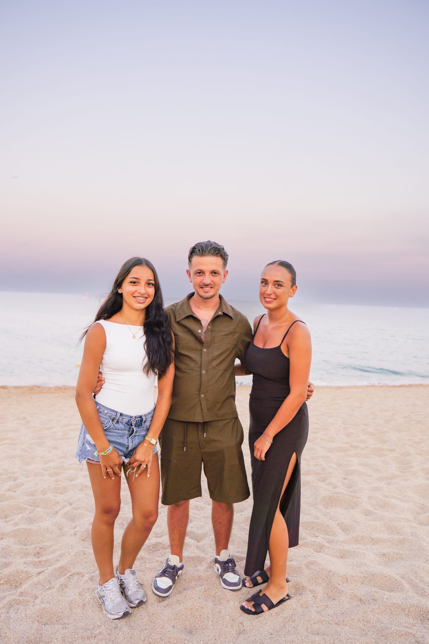 Gezin samen op het strand bij zonsondergang tijdens een gezinsshoot